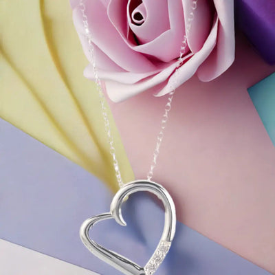 14K silver plated love heart pave pendant necklace on colorful background.